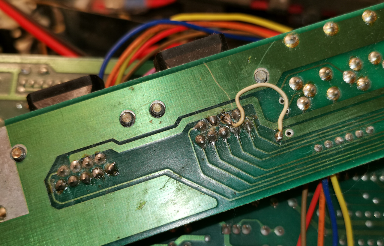 I think at some point in the SX64's past a joystick extension was hard soldered to the back of the I/O PCB.
